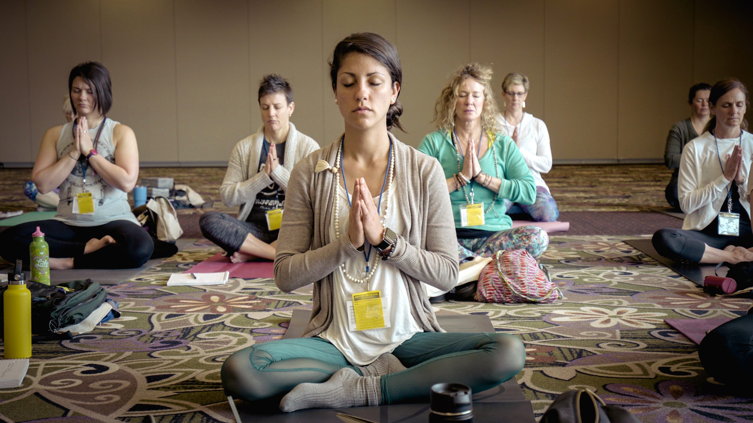 Women sitting peacfully in a yoga pose during a Somatic Breathwork Workshop